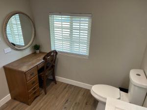 W łazience znajduje się biurko, toaleta i lustro. w obiekcie Adorable One Bedroom Cottage w mieście Oakdale
