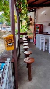 a row of wooden tables and benches in a restaurant at NORDESTINA PiPA in Pipa