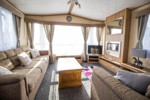 sala de estar con sofá y TV en 8 Berth Caravan With Wifi At Sunnydale Park In Skegness Ref 35241kg, en Louth