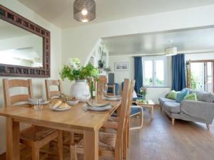 a dining room and living room with a table and chairs at Meadow Pit Cottage in Topsham