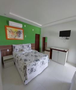 Pousada Solar Da Lagoa - Baixio BA في باكسيو: غرفة نوم بسرير وتلفزيون بشاشة مسطحة