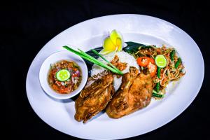 a plate of food with rice and meat and noodles at Swiss-Belexpress Kuta Legian in Kuta