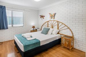 1 dormitorio con 1 cama grande y paredes blancas en Trickett Gardens Holiday Inn, en Gold Coast