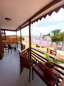 a balcony with wooden benches and a potted plant at Cheerful 2-bedroom home with patio near city center in Willemstad