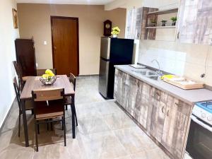 ウィレムスタッドにあるCheerful 2-bedroom home with patio near city centerのキッチン(テーブル、黒い冷蔵庫付) +3枚の写真
