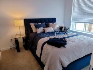 una camera con un grande letto con testata blu di Peaceful Private Room a Surrey