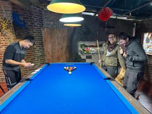 a group of people standing around a pool table at Ninh Binh Bamboo Farmstay in Ninh Binh