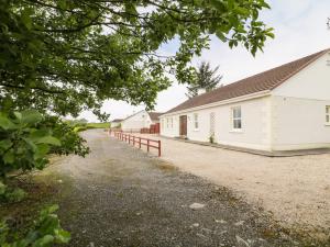 a row of white buildings on a dirt road at Creeslough View in Creeslough