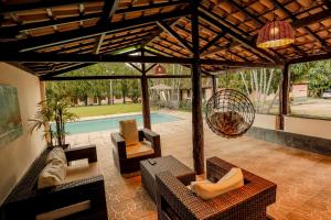 sala de estar con pérgola y piscina en Quatro Estações Pesqueiro e Hotel Fazenda en Esmeraldas