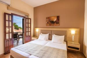 a bedroom with a large bed and a balcony at Aphrodite Luxury Studios & Apartments in Karpathos
