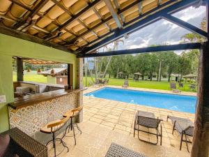 um pátio exterior com uma piscina, cadeiras e uma mesa em Quatro Estações Pesqueiro e Hotel Fazenda em Esmeraldas