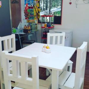 una mesa blanca y sillas con un bol de fruta. en Cafeteria y Cabañas Eluney - Cabaña Laurel, en Pucón