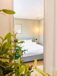a bedroom with a bed and a plant in front of a mirror at Joyce Boutique Coffee & Stay in Da Lat