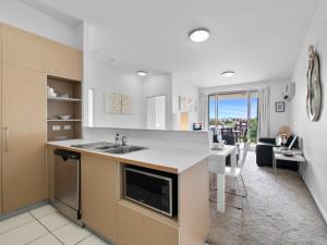 a kitchen and living room with a sink and a table at Artsy Destination Compact & Cosy 2 BR Apart at Valley in Brisbane