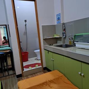 a kitchen with a sink and a bathroom with a toilet at JZA Transient House in Cagayan de Oro