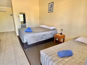 ein Zimmer mit 2 Betten und blauen Handtüchern darauf in der Unterkunft Moura Motel in Moura