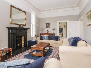 a living room with white furniture and a fireplace at Holcombe House in Torquay