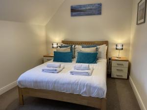 a bedroom with a bed with towels on it at High Tide Cottage in Filey +38 photos