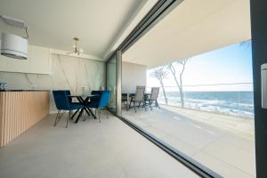 een keuken en eetkamer met uitzicht op de oceaan bij HORIZON HEVENIA Rewal Apartament z dużym tarasem i widokiem na morze in Rewal