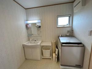 a small white bathroom with a sink and a sinkessment at SHIRAHAMA condominium D-157 in Kanayama