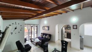 a living room with chairs and a clock on the wall at amplio y comodo apartamento en envigado in Envigado