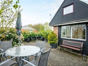een terras met een tafel, stoelen en een parasol bij 6 person holiday home in Skærbæk-By Traum in Skærbæk