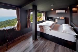 1 dormitorio con cama y ventana grande en Windsor's Sunlight Han-Guan en Jiufen