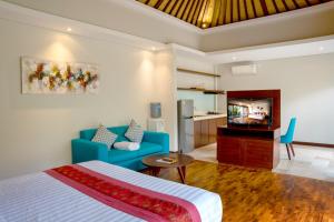 1 dormitorio con 1 cama azul y sala de estar en Sanata Luxury Villa en Canggu