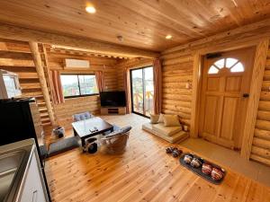 a living room in a log cabin with a door at SHIRAHAMA condominium K-32 in Kanayama