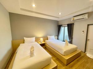 Postel nebo postele na pokoji v ubytování Klaang Muang Hotel (โรงแรมกลางเมือง)