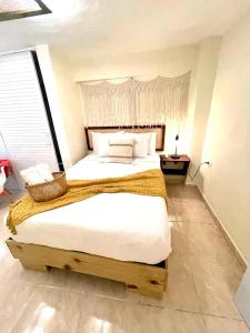 a bedroom with a large bed with a wooden headboard at Studio 27 Colonial, Centro Histórico in Santo Domingo