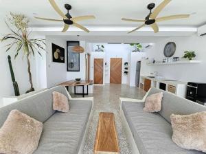 a living room with a couch and two ceiling fans at Villa Endless - Two Bedroom Family Suite - Beachfront Luxury - Bingin Beach in Uluwatu
