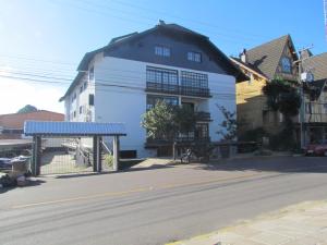 a white building on the side of a street at Apartamento Das Flores in Gramado