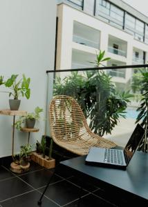 um computador portátil sobre uma mesa com uma cadeira e plantas em Enjoy Luxury Studio w/Pool @Embassy Gardens em Accra