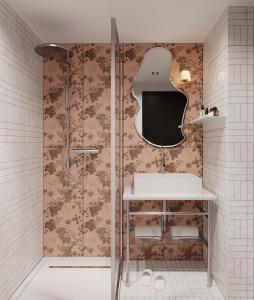 a bathroom with a shower and a sink and a tv at Hotel Les Capitouls Toulouse Centre - Handwritten Collection in Toulouse