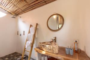 uma casa de banho com um lavatório de pedra e um espelho. em Elysium Bingin em Uluwatu