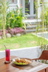 a plate of food on a table with a drink at Elysium Bingin in Uluwatu