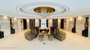 a lobby with a chandelier and a table and chairs at MINIMALIST, STYLISH, ELEGANT - at FAME RESIDENCES in Manila