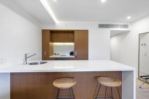 a kitchen with a counter and two stools at Sapphire Suite- Family friendly in Cairns