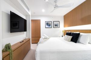 a bedroom with a large bed with a flat screen tv at Sapphire Suite- Family friendly in Cairns