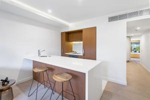 a kitchen with a white counter and stools at Sapphire Suite- Family friendly in Cairns