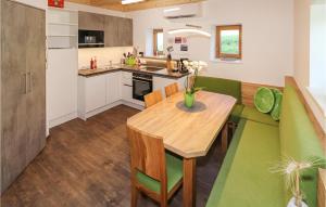 a kitchen with a wooden table and a green couch at Cozy Home In Eltendorf With Wifi in Eltendorf