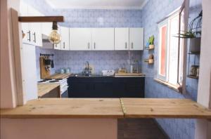 a kitchen with white cabinets and a wooden counter top at H2A in Aroeira