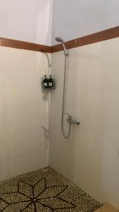 a shower in a bathroom with a tile floor at Bali Cottage Sambirenteng in Buleleng