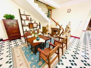 a dining room with a table and chairs and a fireplace at Thanh Xuân House in Xuan An