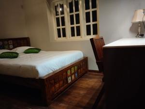 - une chambre avec un lit, un bureau et des fenêtres dans l'établissement INN THE MOUNTAIN'S, à Kodaikānāl