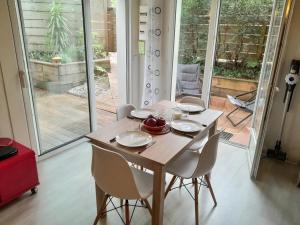 a dining room table with white plates and chairs at Appartement T1 bis tout confort, proche plages et commerces, Capbreton - FR-1-239-954 in Capbreton +7 photos