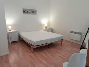 a bed in a room with two night stands at Appartement T1 bis tout confort, proche plages et commerces, Capbreton - FR-1-239-954 in Capbreton