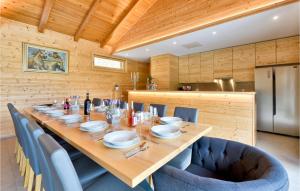 une grande table en bois avec des chaises bleues et une cuisine dans l'établissement Four-bedroom Holiday Home, à Lepajci