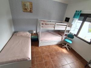 a small bedroom with two bunk beds and a window at LANZATE! in Tinajo